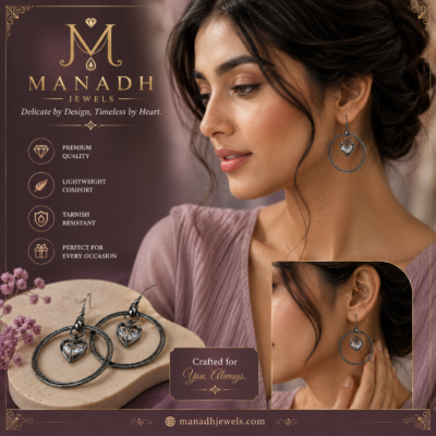Elegant black hoop earrings featuring sparkling heart-shaped crystal charms displayed on a premium jewellery stand by MANADH JEWELS.