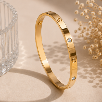 Gold-tone polished bangle with circular detailing and sparkling crystal accents