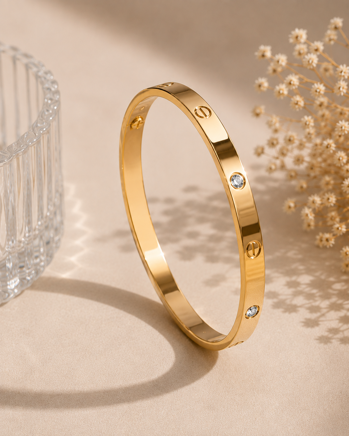 Gold Tone Crystal Accent Bangle MND-BR005 Slide2 Gold-tone polished bangle with circular detailing and sparkling crystal accents