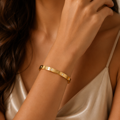 Gold-tone polished bangle with circular detailing and sparkling crystal accents