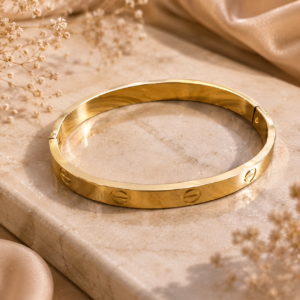 Gold-tone minimalist bangle with polished finish and subtle circular engraved-style detailing