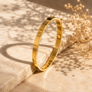 Gold-tone minimalist bangle with polished finish and subtle circular engraved-style detailing