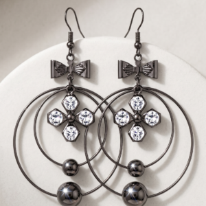 Elegant bow crystal drop earrings by MANADH Jewels featuring a polished metallic circular design with sparkling crystal accents on a premium beige background