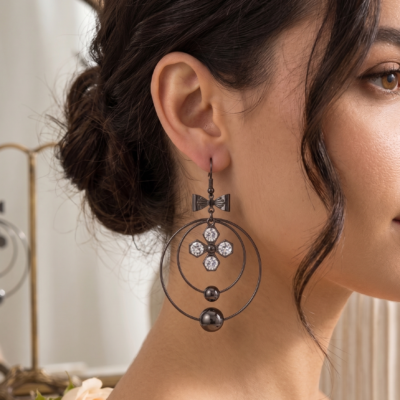 Elegant bow crystal drop earrings by MANADH Jewels featuring a polished metallic circular design with sparkling crystal accents on a premium beige background