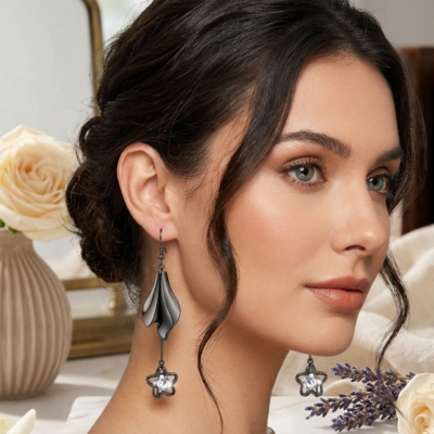 Luxury silver designer drop earrings for women by MANADH Jewels showcased on a female model wearing an elegant emerald green saree in a premium jewelry catalogue with warm editorial lighting