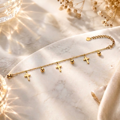 Manadh Jewels Cross Charm Gold Bracelet featuring minimalist gold cross charms, polished bead accents, adjustable stainless steel chain, and elegant tarnish-resistant finish on a luxury marble background.
