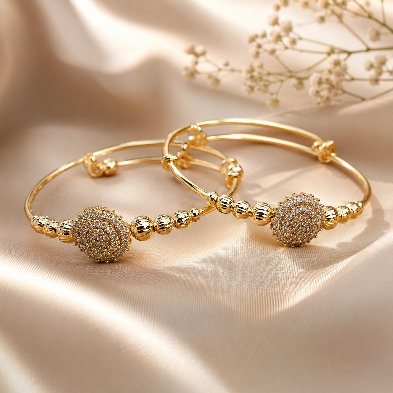 Kada MND-BR009 Slide2 MANADH JEWELS gold bangle bracelet set with intricate diamond-style floral detailing displayed on a luxurious marble stand with elegant golden lighting