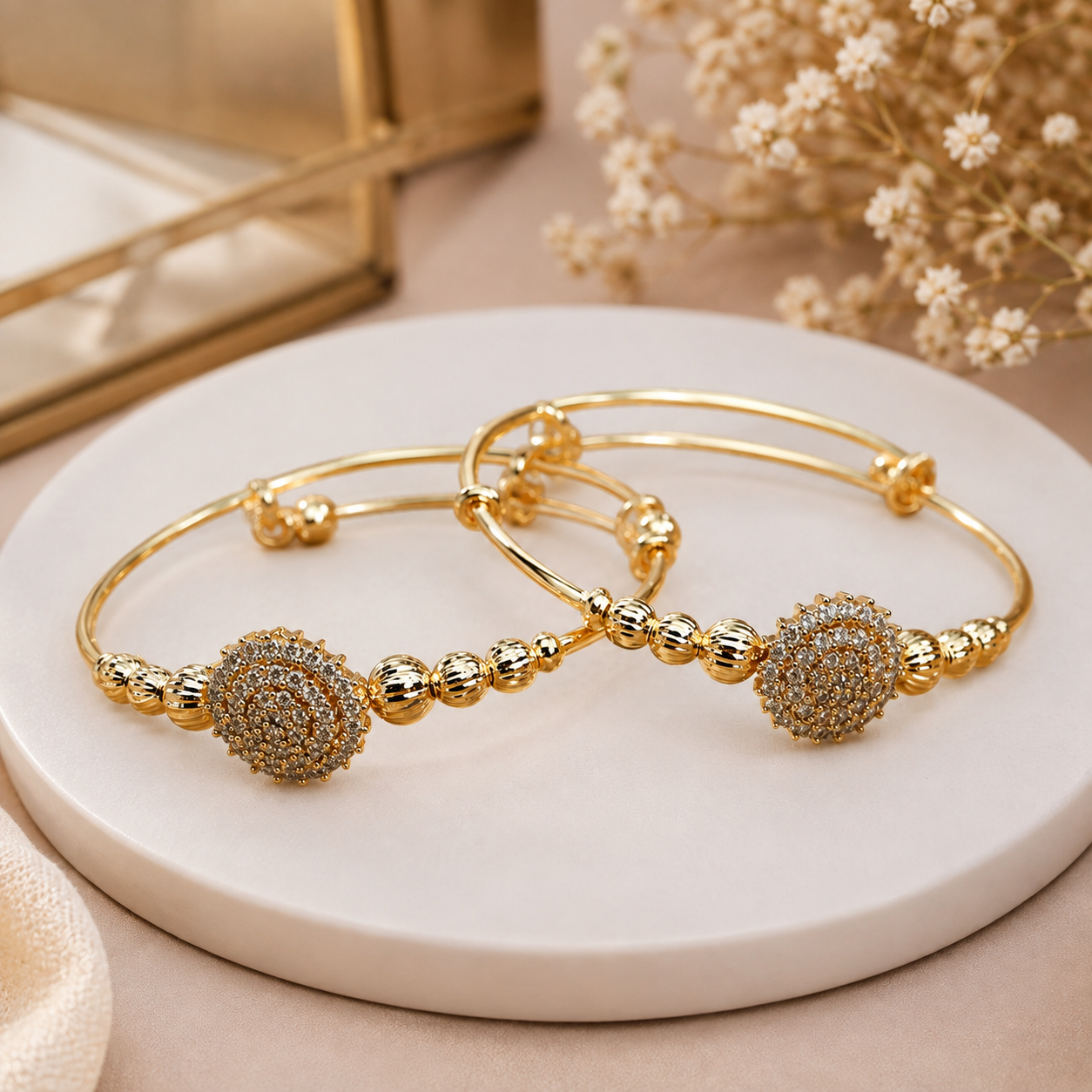 Kada MND-BR009 Slide4 MANADH JEWELS gold bangle bracelet set with intricate diamond-style floral detailing displayed on a luxurious marble stand with elegant golden lighting