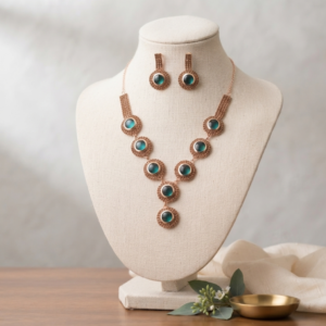 Manadh Jewels gold-plated green stone necklace set with matching earrings displayed on a luxury brown velvet background for festive and bridal jewellery collection