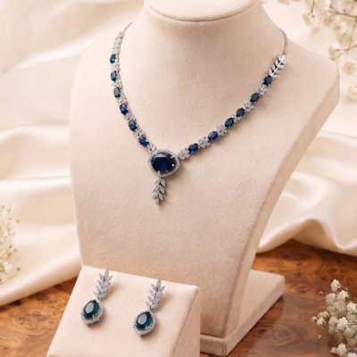 Royal Blue Sapphire Crystal Necklace Set by Manadh Jewels featuring sparkling sapphire-inspired blue stones, premium zircon detailing, matching drop earrings, and an elegant silver-tone design for bridal wear, weddings, receptions, parties, and festive occasions