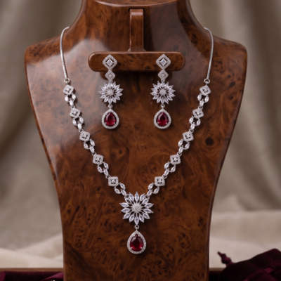 Manadh Jewels Floral Ruby Crystal Necklace Set with matching drop earrings featuring premium crystal floral motifs and ruby-red pear-shaped stones, ideal for bridal wear, weddings, festive celebrations, receptions, and party occasions