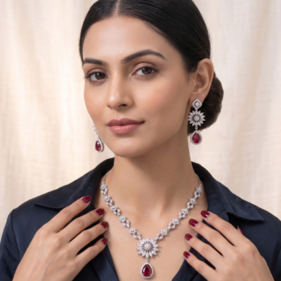 Manadh Jewels Floral Ruby Crystal Necklace Set with matching drop earrings featuring premium crystal floral motifs and ruby-red pear-shaped stones, ideal for bridal wear, weddings, festive celebrations, receptions, and party occasions