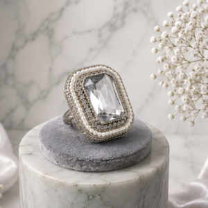 Silver statement ring by Manadh Jewels featuring a large emerald-cut clear crystal in a vintage-inspired rectangular setting, displayed in front, side, back, and angle 360-degree views.