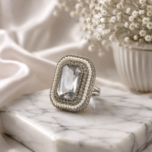 Silver statement ring by Manadh Jewels featuring a large emerald-cut clear crystal in a vintage-inspired rectangular setting, displayed in front, side, back, and angle 360-degree views.