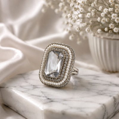 Silver statement ring by Manadh Jewels featuring a large emerald-cut clear crystal in a vintage-inspired rectangular setting, displayed in front, side, back, and angle 360-degree views.