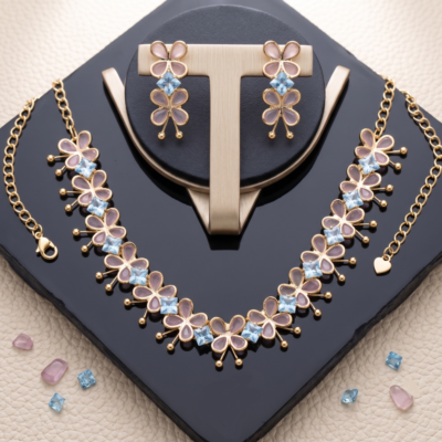 Gold-toned lightweight jewelry set by Manadh Jewels featuring a necklace and matching earrings with pink butterfly motifs and clear American diamond stones