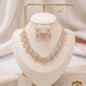 Gold-toned lightweight jewelry set by Manadh Jewels featuring a necklace and matching earrings with pink butterfly motifs and clear American diamond stones