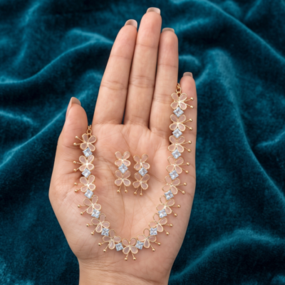 Gold-toned lightweight jewelry set by Manadh Jewels featuring a necklace and matching earrings with pink butterfly motifs and clear American diamond stones