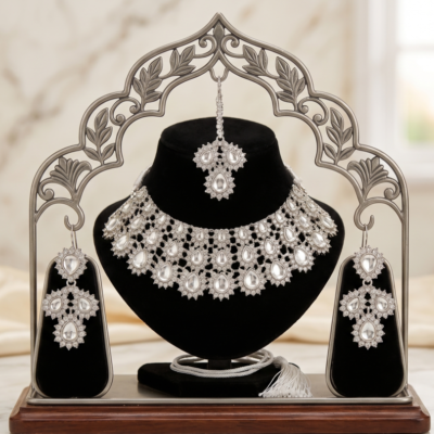silver stone bridal choker necklace set with matching earrings and maang tikka on black velvet display