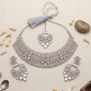 Manadh Jewels silver-tone bridal choker necklace set featuring intricate floral motifs and clear crystal mirror-style stones, complete with matching drop earrings and a coordinating maang tikka