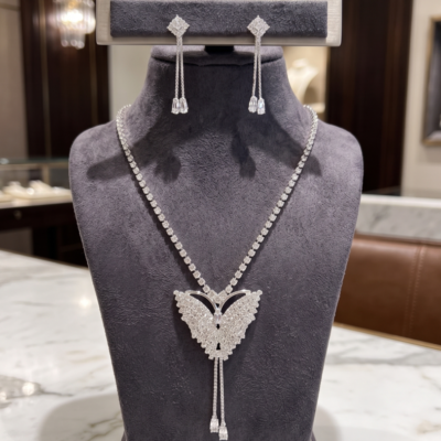 Radiant butterfly necklace and matching drop earrings with sparkling clear crystal-style stones by Manadh Jewels