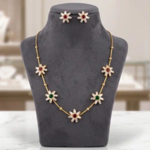 Gold-tone necklace set featuring floral pendants with white, red, and green stones alongside matching stud earrings