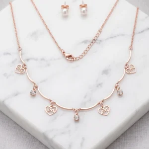 Rose gold-tone necklace with heart charms reading LOVE and YOU alongside pearl stud earrings