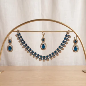 Antique gold-plated traditional Indian choker necklace set featuring deep royal blue stones, accompanied by matching drop earrings and a maang tikka